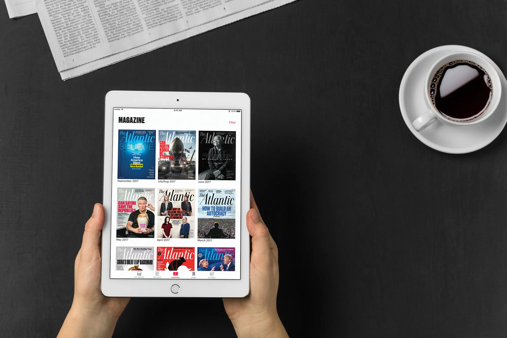 Magazine shelf in the iPad app, held over a desk with coffee